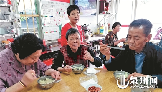 老人欢聚一堂，共享免费午餐。 