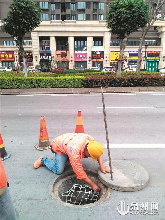 工作人员巡查雨水口 工作人员巡查雨水口
