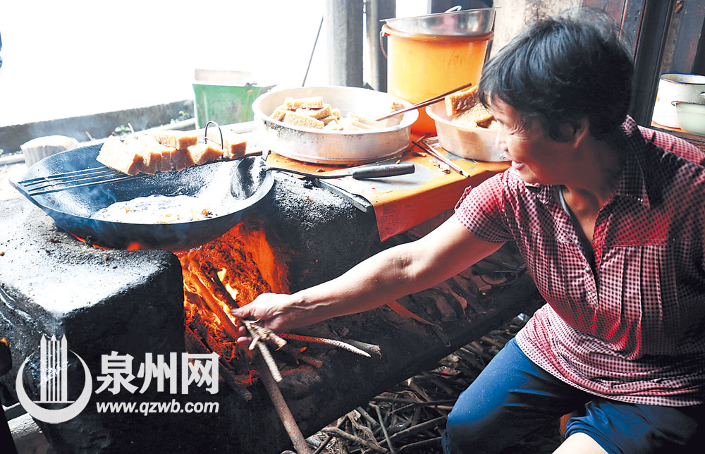 吴阿婆在添柴火，据说柴火烧出来的炸粿比较香。