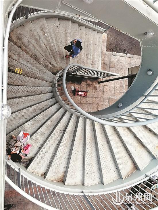 旋转楼梯的台阶上有大片污渍，而且被贴广告。 