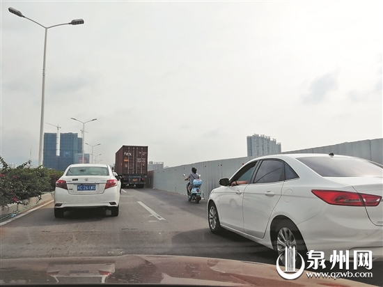 电动车跟在大货车后方行驶