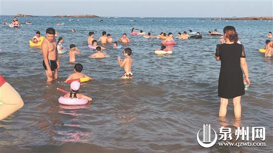 在晋江围头金沙湾，一些小孩子没有安全防护措施就下海玩水。 