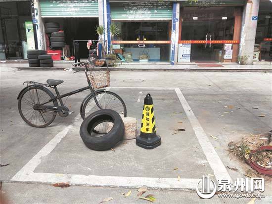 在淮云路,反光锥、废旧轮胎等成为私占公共停车位的工具。 在淮云路,反光锥、废旧轮胎等成为私占公共停车位的工具。