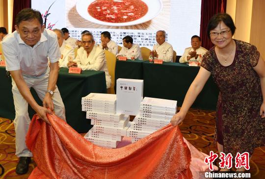 福建省闽菜技艺研究会会长强振涛(左)，福建人民出版社副社长曹希莎(右)共同为《中国闽菜》正式出版“掀起盖头来”。　记者刘可耕 摄