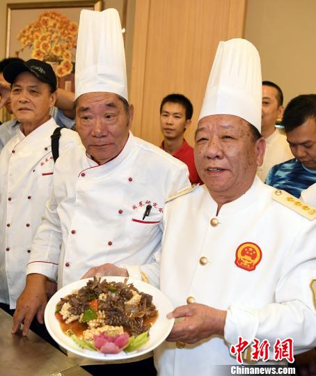闽菜大师强木根首徒陈依宇(左二)与闽菜大师强曲曲首徒姚建明(右一)联袂合作表演烹饪经典闽菜“爆炒双脆”。　记者刘可耕 摄