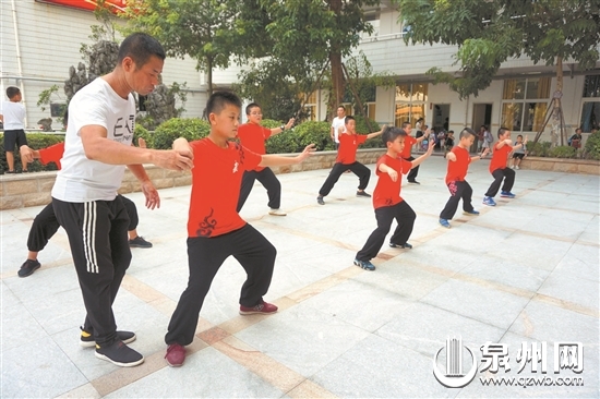 放学后，孩子们在老师的指导下练习太极拳。 