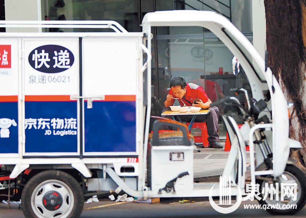 一名快递员在路边摊迅速解决午饭继续送货。昨日中午摄于天后路。