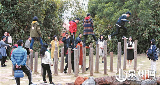2月10日，泉州少林寺游人如织，一些小朋友正在体验少林武僧的梅花桩。 （陈英杰 摄）