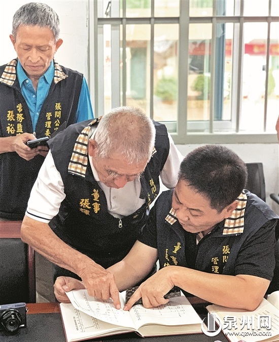 张宇讃（右一）和同行的台湾张氏宗亲仔细查看族谱 