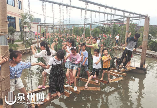 端午小长假期间，我市各地纷纷推出民俗展演、乡村体验、亲水休闲游等旅游产品，备受游客青睐。图为游客在永春县桃城镇南星社区美丽乡村体验亲水项目。（姚德纯 陈小阳 摄）