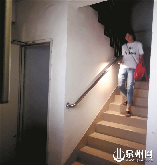 电梯停用，住户用手机照明下楼梯。