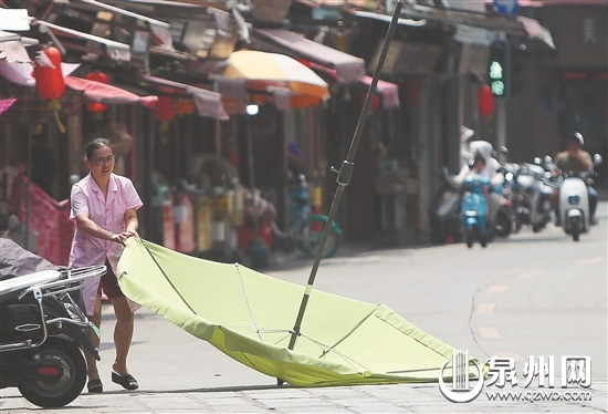 天气炎热，遮阳伞可不能翻。