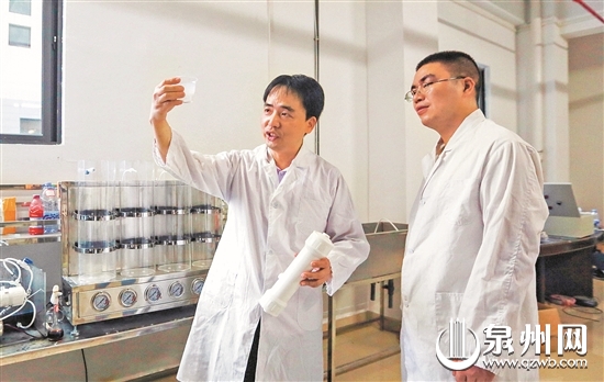 实验室中，吴特殊（左）与团队人员潜心研究膜技术。