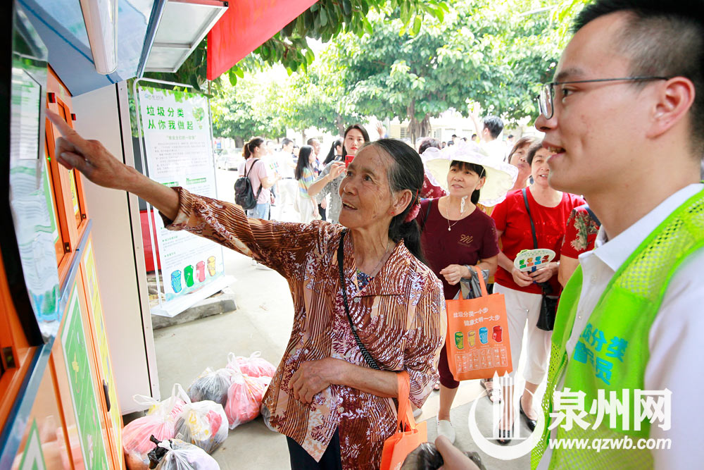 74岁的美华阿婆在垃圾分类督导员的帮助下，学习如何扫描二维码、选定垃圾类型后将垃圾投到合适的垃圾箱
