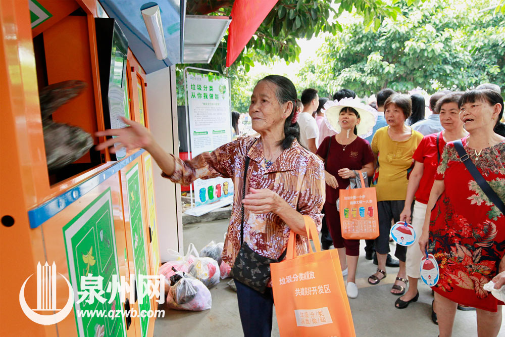 74岁的美华阿婆在垃圾分类督导员的帮助下，学会了扫描二维码后将垃圾投入合适的垃圾箱