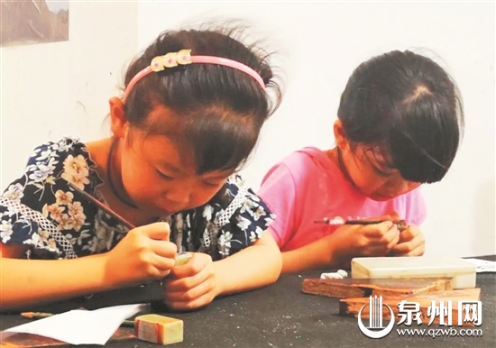 在惠安紫山莲坑小区，孩子们刻着手中的青田石方印。