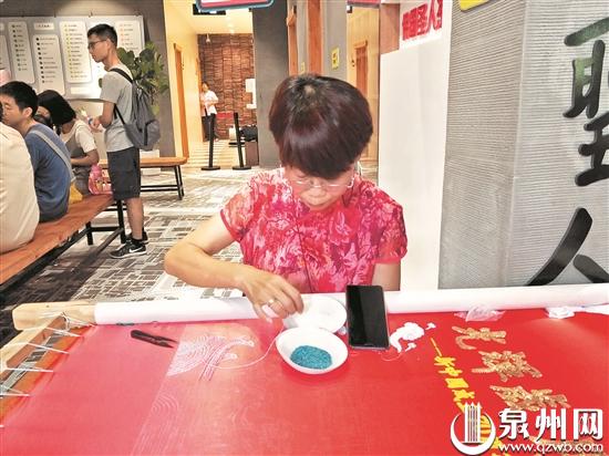 10月2日，西街游客服务中心，非遗传承人陈克忍展示金苍绣。 （许雅玲 摄）