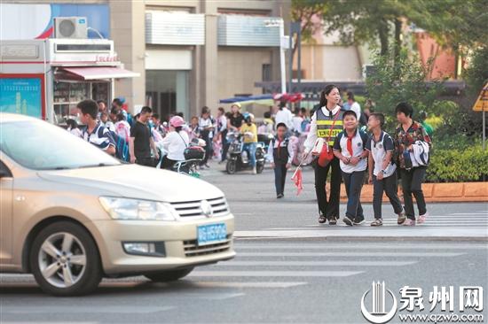 家长开展爱心护学活动,引导学生过马路。 家长开展爱心护学活动,引导学生过马路。