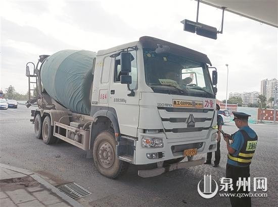 执法人员对经过的水泥罐车进行检查 执法人员对经过的水泥罐车进行检查