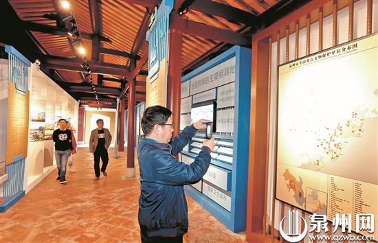 泉州市情展刚完成布展,有些游客已前来先睹为快。图为来自北京的周先生(右一)在拍摄展出的图片。 泉州市情展刚完成布展,有些游客已前来先睹为快。图为来自北京的周先生(右一)在拍摄展出的图片。