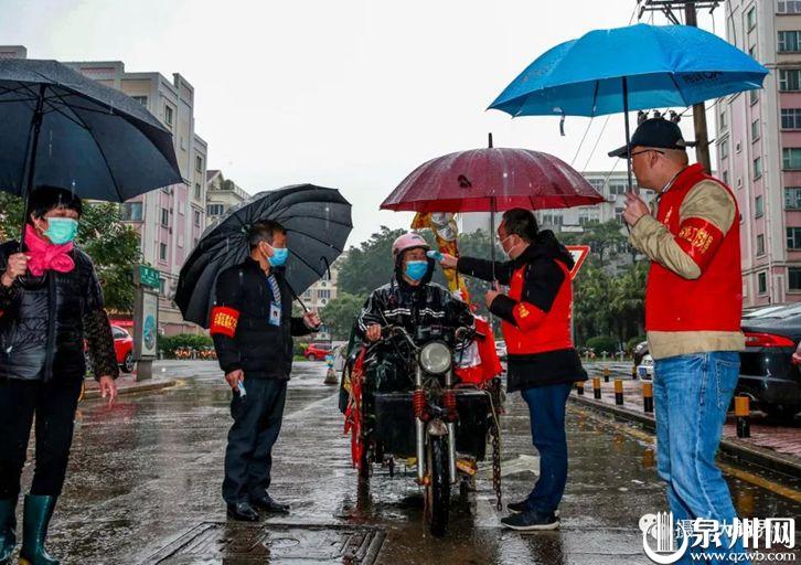 许多党员做表率、身先士卒冲锋在战斗一线，这是白天在丰泽东凤社区，党员在雨中检测。（陈英杰 摄）