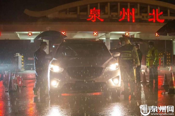 2月15日22时38分，在高速公路泉州北收费处，泉州市交通局执法五大队的执法人员正对车辆的旅客进行检查和测量体温。在疫情防控工作一线，广大执勤民警坚守在岗位，逆风迎雨，丝毫没有受天气的影响。（陈英杰 摄影）