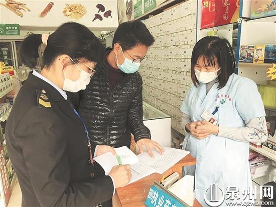 工作人员检查口罩销售登记情况