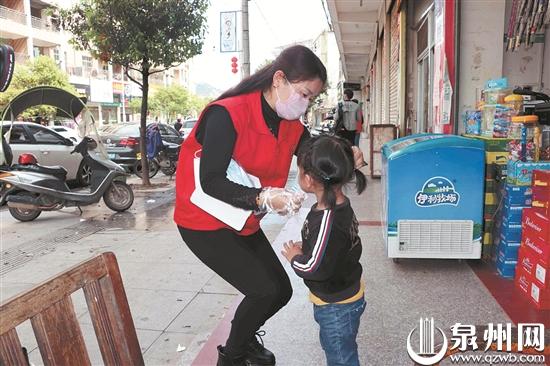 志愿者为小孩戴口罩