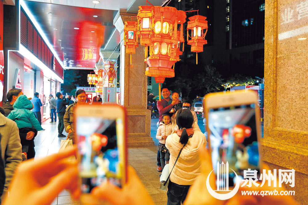 泉州商城广场上，一家子在灯下幸福合影。（林劲峰 摄）