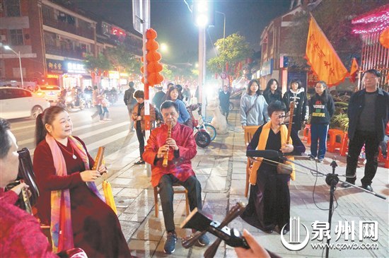 鲤城区32处布灯点之一六井孔创意园对面，南音表演吸引市民驻足欣赏。（陈灵 摄）