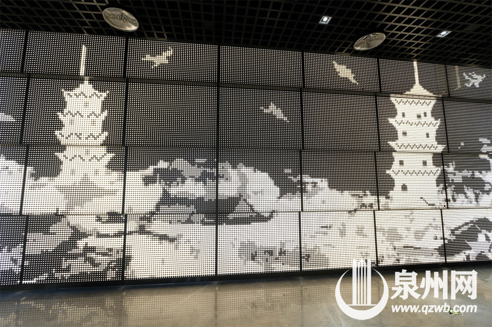 泉州市科技与规划馆主门厅里，由穿孔铝板灯箱投射成的东西塔墙面，传递出科技感。