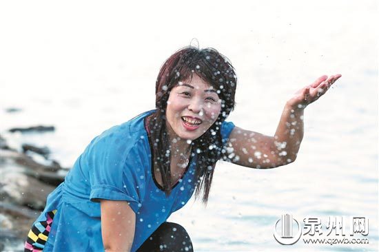 8月7日，在金门县田埔水库，1995年从晋江围头村嫁到金门的洪燕明兴奋地扬起来自家乡晋江的水。