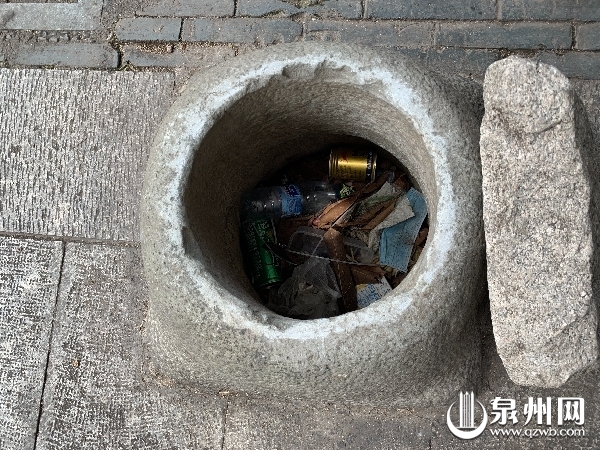 肃清门广场上的孤闷小井，井口被塞满各种垃圾。