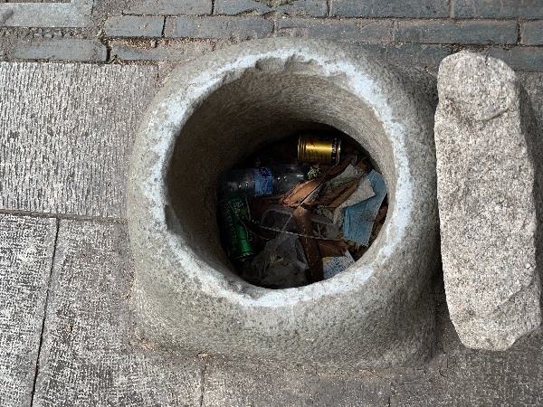 肃清门广场上的孤闷小井，井口被塞满各种垃圾。